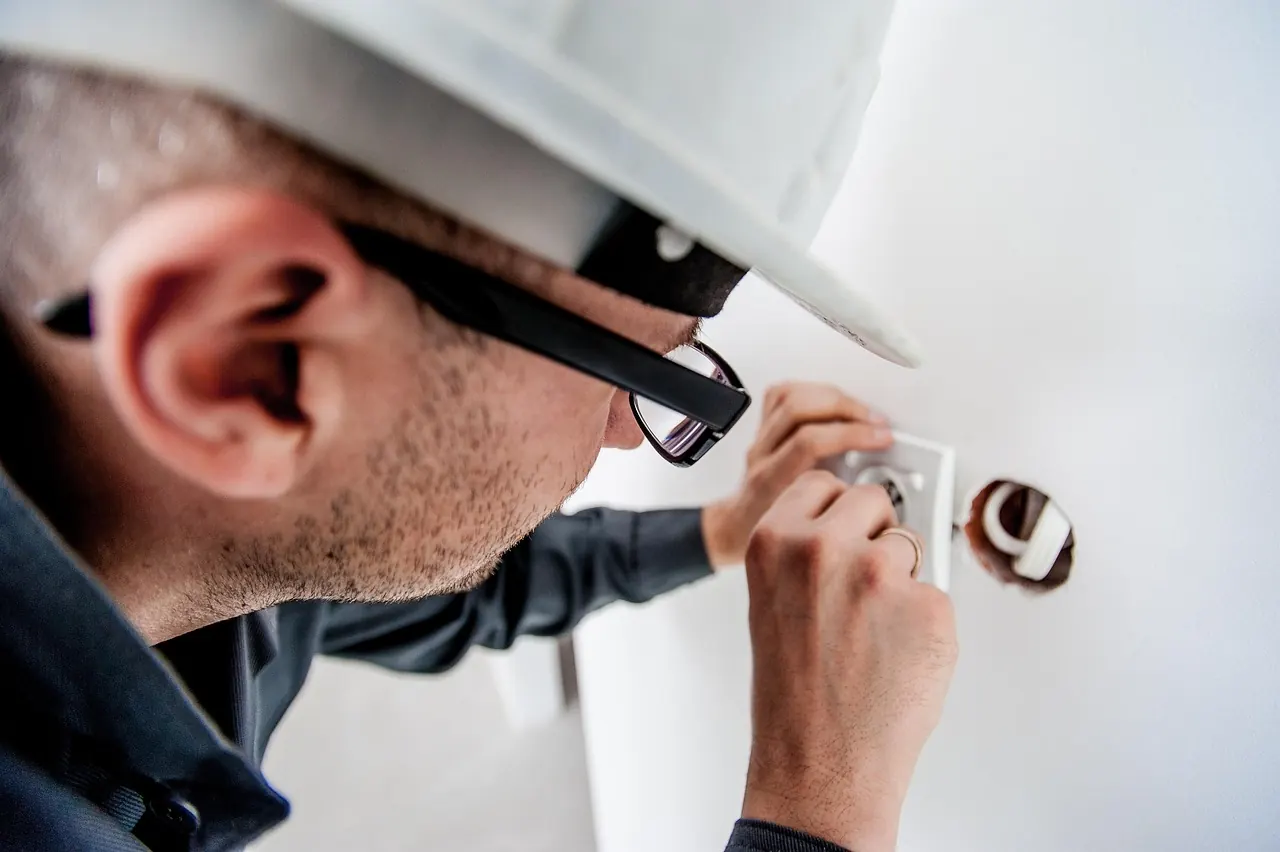 Électricien installant une prise murale